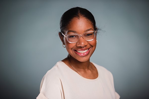 Professional headshot of a smiling Chelsea Wysinger wearing a beige shirt against a light grey backgound.