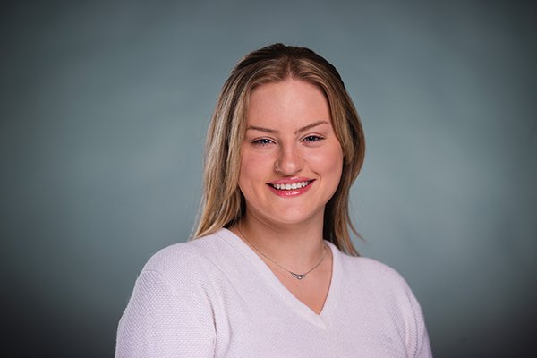 Professional headshot of a smiling Lauren Allen wearing a white shirt against a light grey backgound.