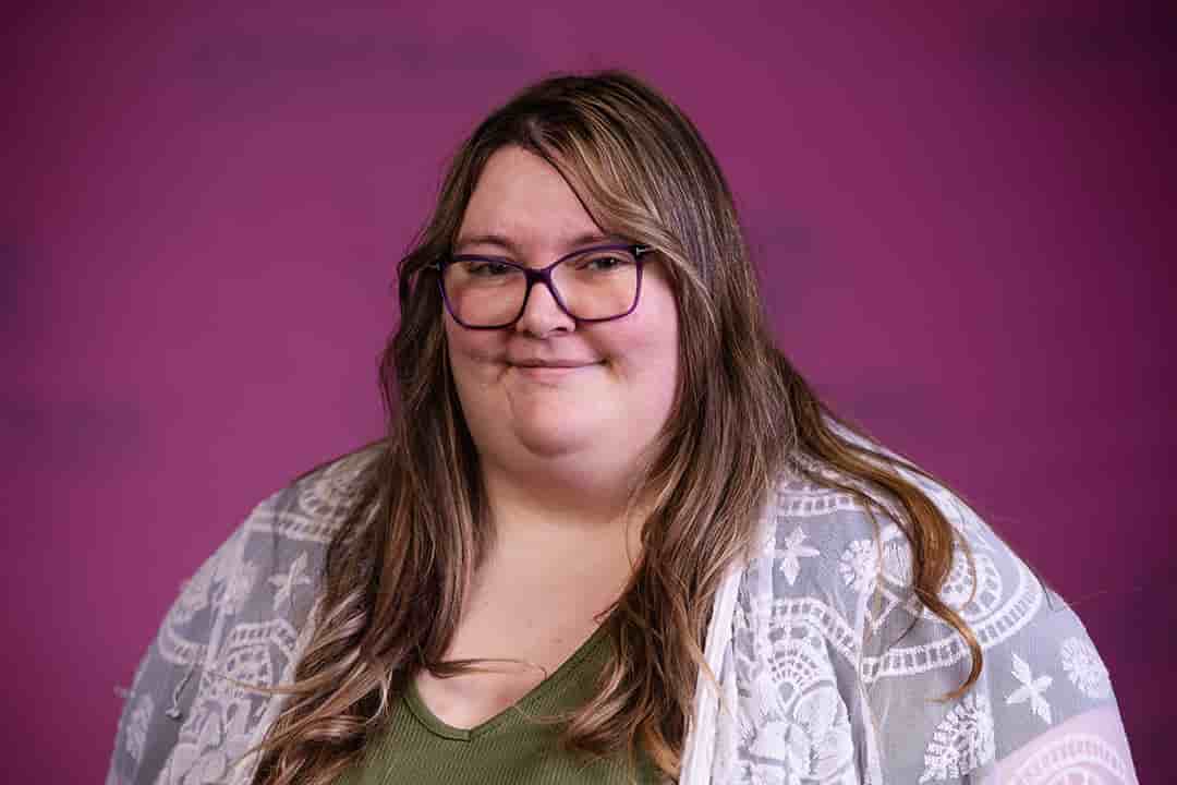 Professional headshot of Amy Ferguson wearing a green shirt with sheer white sweater while looking at the camera.