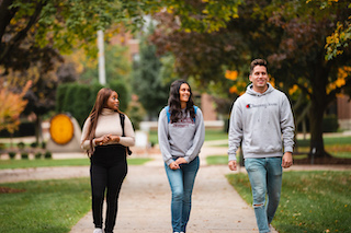 three CMU students walking through campus