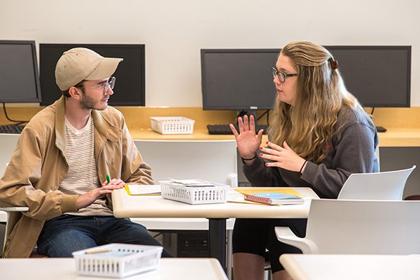 Two students talking at a table