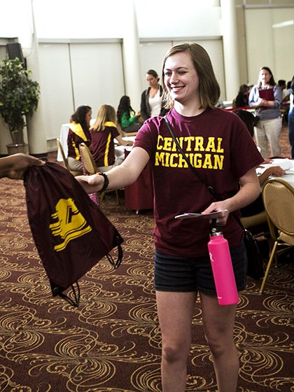 Student receives bag of goodies at New Freshmen Orientation