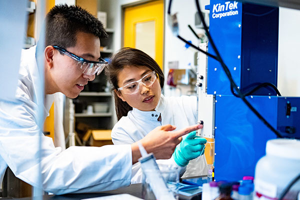 a student and instructor in a lab with googles on