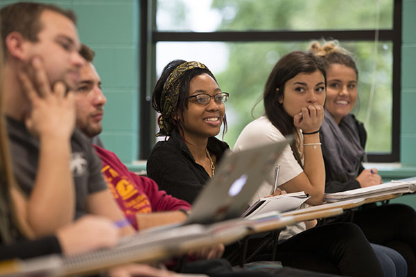 students sitting in desks in a row in a classroom