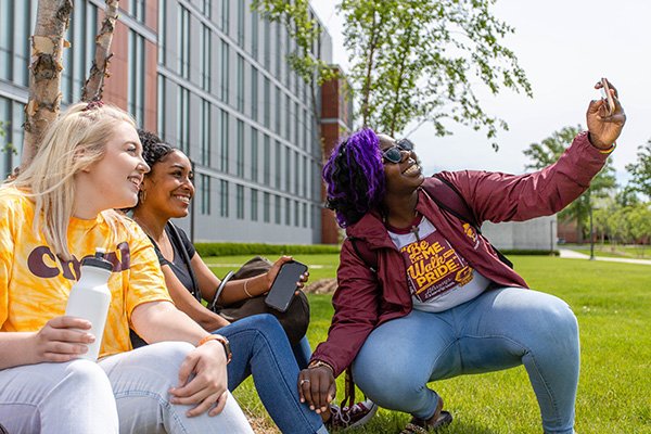 Students on lawn at CMU taking a photo together