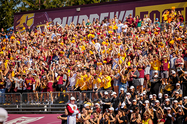 The student section is shown cheering during a CMU football game. 