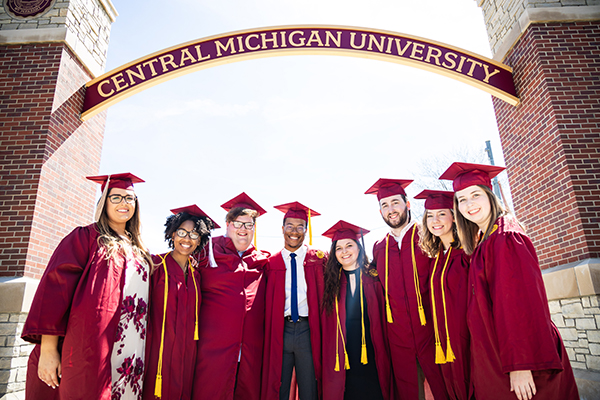 A group of proud Central Michigan students in graduation caps and gowns