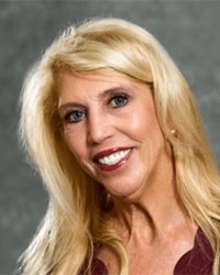 Jan Hagland is an Advancement Board member and she is wearing a maroon top and she has long blonde hair.