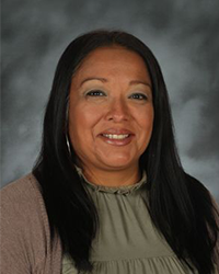 A professional headshot photo of Melissa DeJesus in front of a gray background.