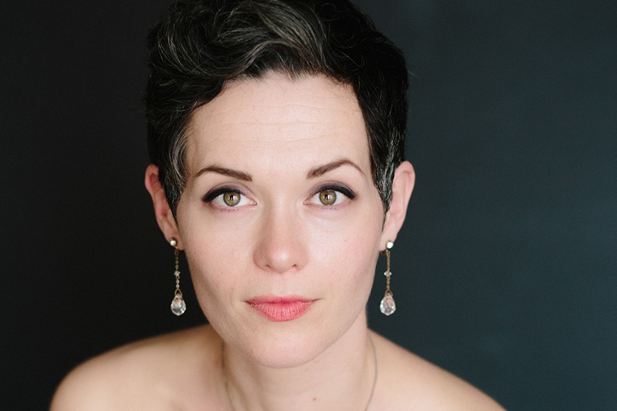 A headshot of Emily Marvosh against a dark background.