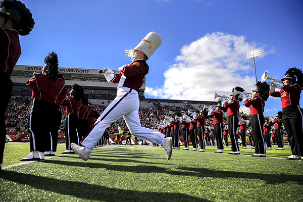 The Central Michigan University marching band marching on the football field.