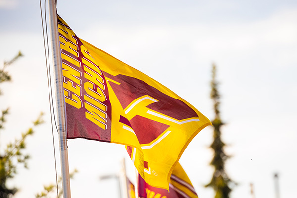 A maroon and gold Central Michigan University flag with the action C