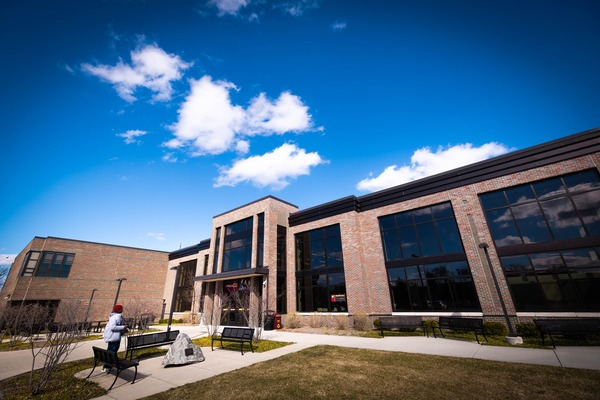 Exterior view of Grawn Hall, a multi-story brick academic building on the CMU campus under a clear blue sky.