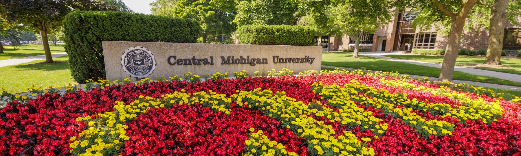 The Central Michigan University sign and colorful flowers displayed on campus.