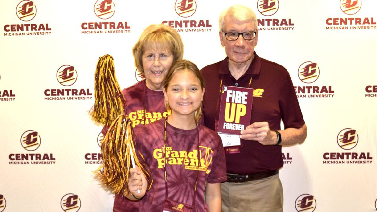 A group of people posing for a photo in front of a Central Michigan University step-and-repeat backdrop.
