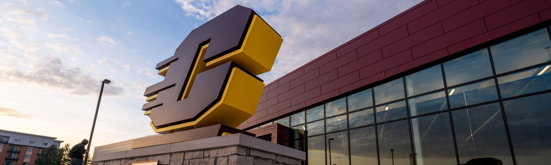 Close-up of the Action C signage in front of the CMU Athletics building entrance.