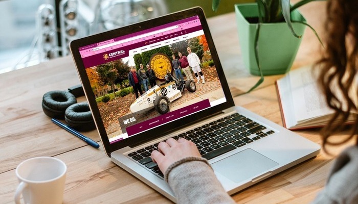 alumni_email_700x400 A person using a laptop displaying the Central Michigan University website.
