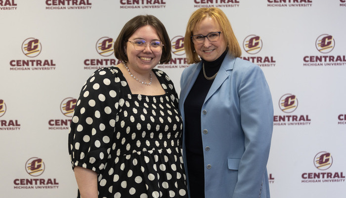 alumni_scholarships_700x400 Two women pose in front of a Central Michigan University backdrop.