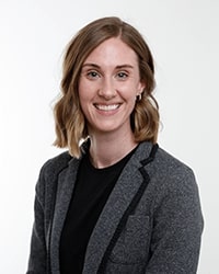 This is a headshot of Stefanie Gray wearing a black top and gray blazer.