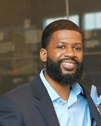 This is Vincent Parker's headshot photo in a blue button up and gray blazer.