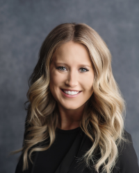 Emily Daunt 200x250 A woman with long blonde hair and a black shirt is smiling.