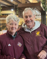 Gary and Cathy Collins 200x250 A man and woman wearing maroon jacket. The woman's has an Adidas logo showing and the man's has a Central Michigan logo.
