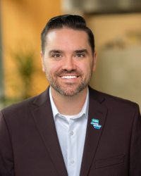 Michael Hull 200x250 Headshot of a man with short facial hair and dark hair wearing a dark suit and white dress shirt.