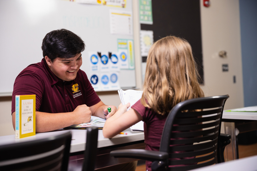 Teacher and student collaborating in a classroom.