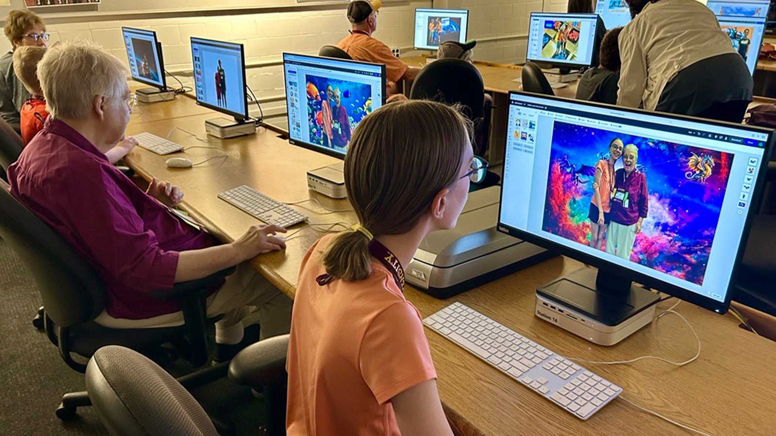 A group of people sitting at computers with photo-editing software on their screens.