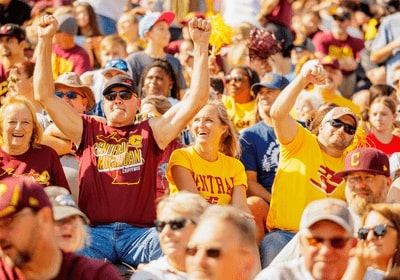 CMU Alumni in maroon and gold at Kelly/Shorts stadium cheering for the CMU Chippewas.