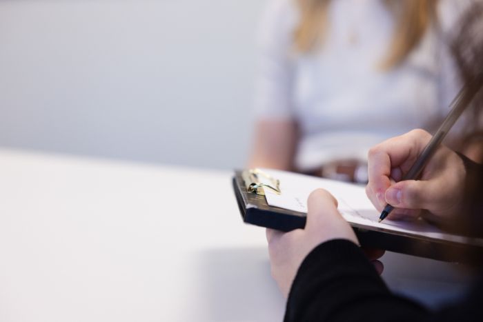 A person using a clipboard to fill out paperwork.