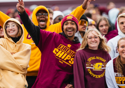 A group of students clad in maroon and gold at the football game.