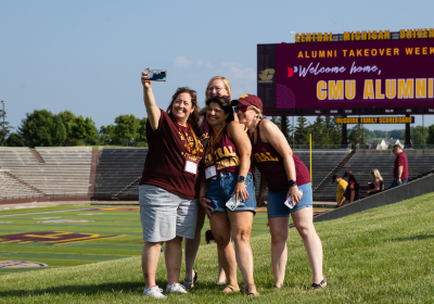 A group of four alumnae taking a selfie at Kelly/Shorts Stadium.