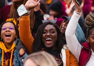 Women in the stands of Kelly/Shorts stadium cheering and smiling.