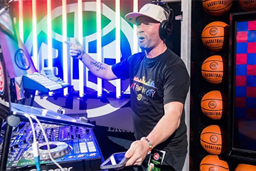 A man wearing headphones and pointing at a music player.