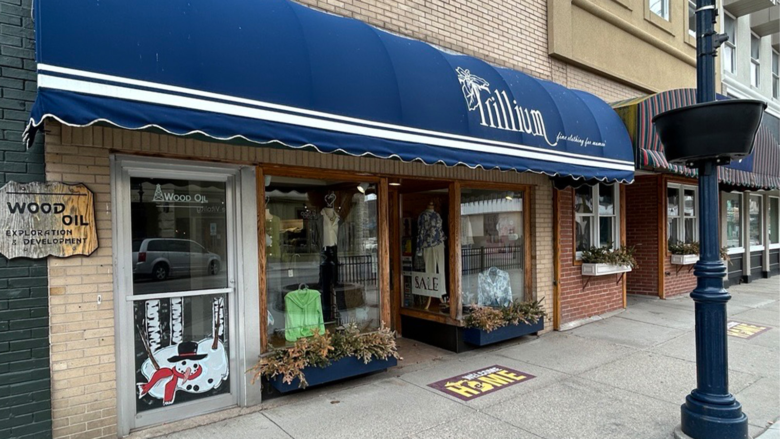 A storefront with a blue awning with the word Trillium on it.