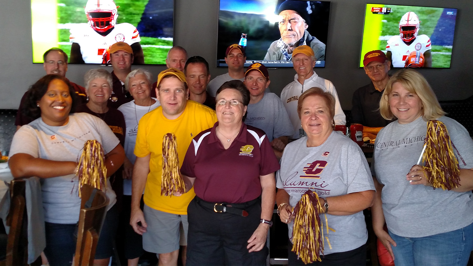 A group of people, many with Central Michigan University shirts on, pose for a photo.