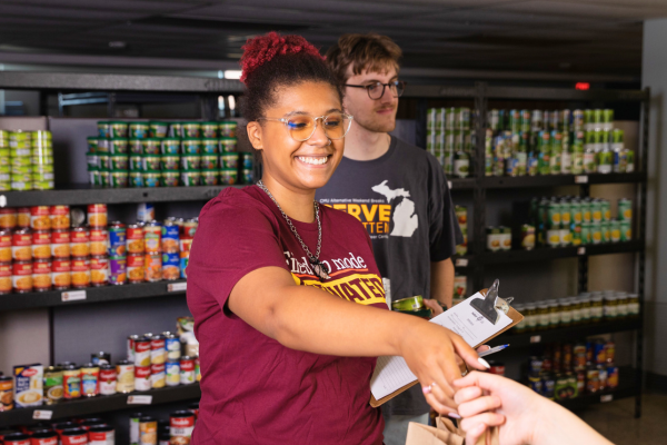 Two students are pictured in the Student Food Pantry .