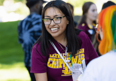 Female student with dark hair, glasses, and maroon CMU shirt smiling.