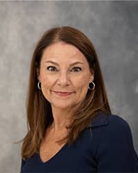 Cheryl Danner, Counselor Cheryl Danner, Counselor, professional headshot picture, wearing a dark blue shirt, with a grey background