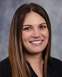 Cecily Barnaud, Student Athlete Dedicated Counselor Cecily Barnaud, Student Athlete Dedicated Counselor profile portrait, smiling, wearing a black top with a grey background