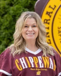 200x250 26-09-16 Leah Rutkowski - mh-6 Leah Rutkowski, Director of Oros Well-th Scholars and COMPASS Peer Education Program. Blonde hair, wearing a maroon Chippewas shirt. The background is a portion of the CMU maroon and gold seal and green trees.