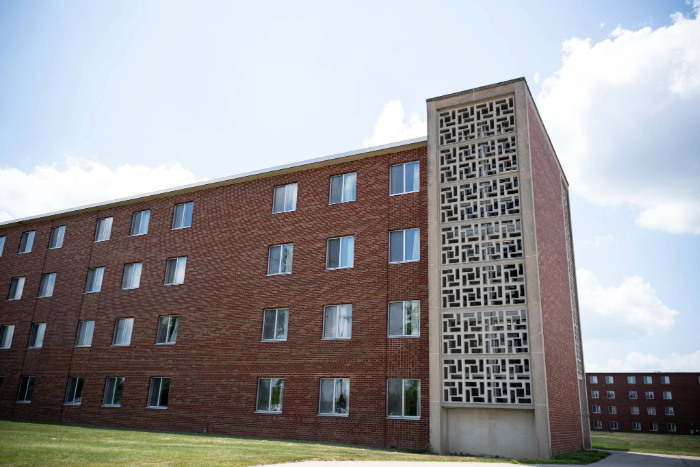 Side view of Emmons Hall showing a red brick facade and a decorative concrete stairwell panel.