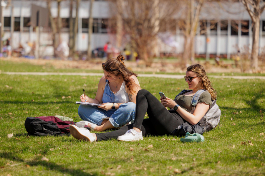 24-04-09 -0013-Spring Scenics (1) Two CMU students studying and sitting in the lawn on campus