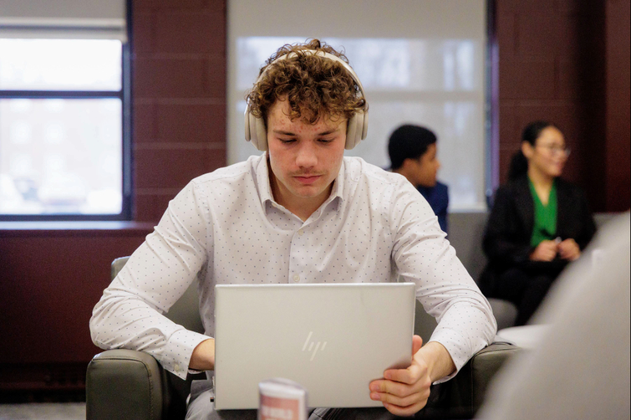 26-02-06 Grawn VMD International Student VMD-0079 (1) CMU student sitting staring at laptop with headphones on