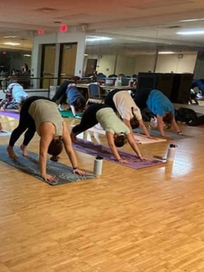 people doing a yoga pose in the wellness studio of the CMU SAC