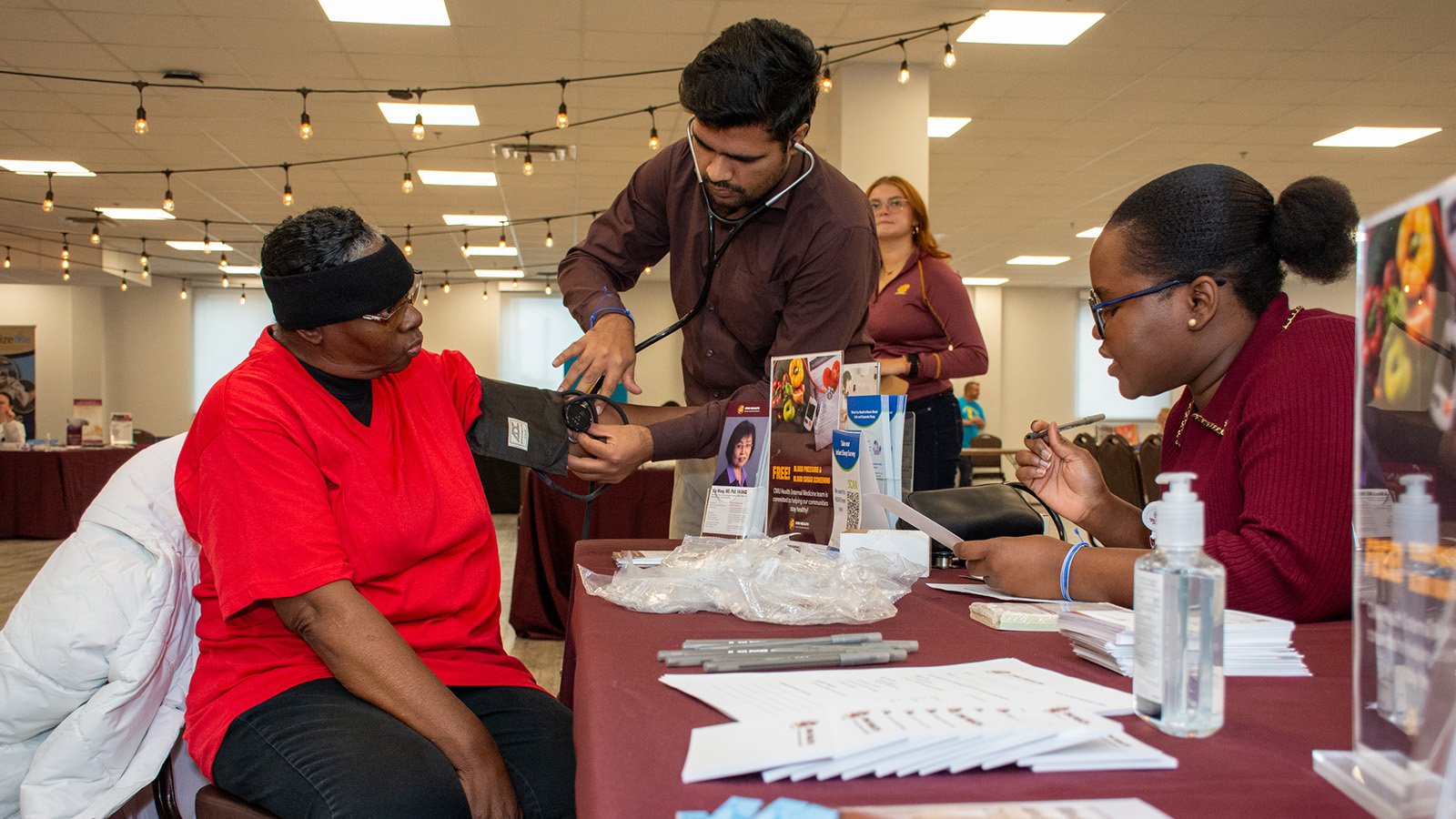 a man measuring a woman's blood pressure