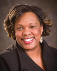 Professional headshot of Delicia Pruitt, M.D., wearing a black blazer against a dark background.