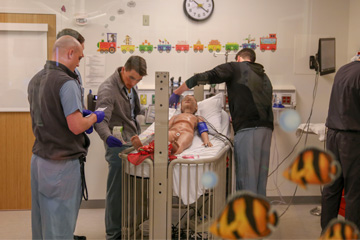 Four emergency resident physicians working in medical simulation.