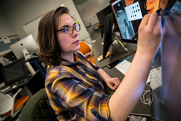 Student using drawing on a computer screen in the art and design graphics lab
